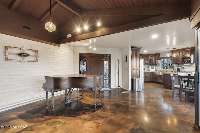 interior space featuring light stone counters, hanging light fixtures, dark brown cabinets, and lofted ceiling with beams