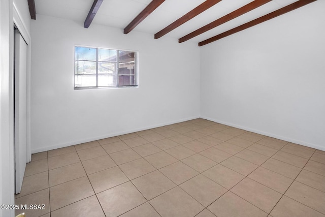 empty room featuring vaulted ceiling with beams