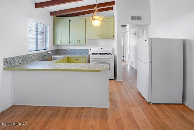 kitchen with sink, kitchen peninsula, green cabinets, pendant lighting, and white appliances