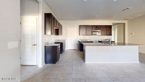 kitchen with a center island with sink, stainless steel microwave, and light countertops