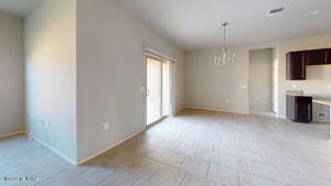 unfurnished living room with an inviting chandelier and visible vents