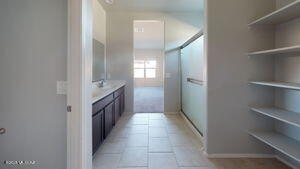 bathroom with baseboards, an enclosed shower, and tile patterned floors