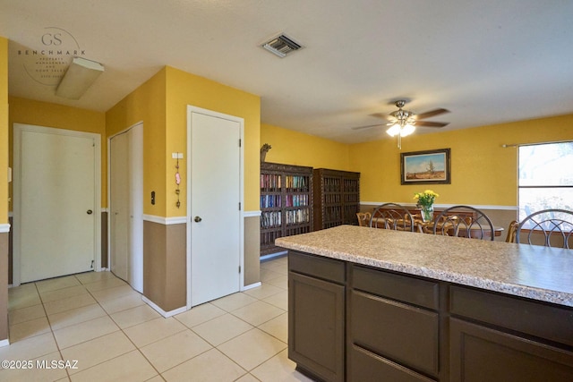 kitchen with visible vents, dark brown cabinetry, light countertops, light tile patterned floors, and ceiling fan