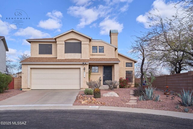 traditional-style house featuring stucco siding, concrete driveway, an attached garage, and fence