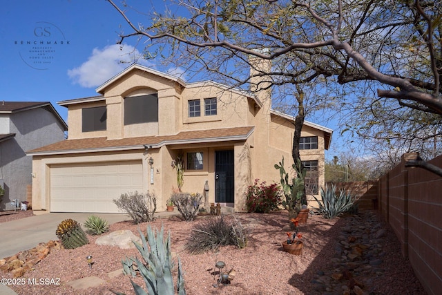 view of front of home with stucco siding, a garage, driveway, and fence