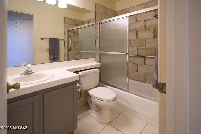 bathroom with tile patterned flooring, combined bath / shower with glass door, toilet, and vanity