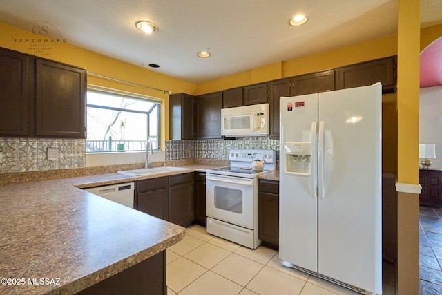 kitchen featuring a sink, white appliances, dark brown cabinetry, light tile patterned floors, and decorative backsplash