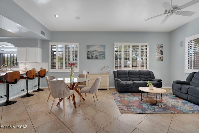 tiled living room featuring ceiling fan and sink