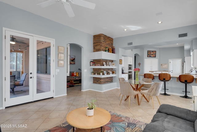 tiled living room with french doors and ceiling fan