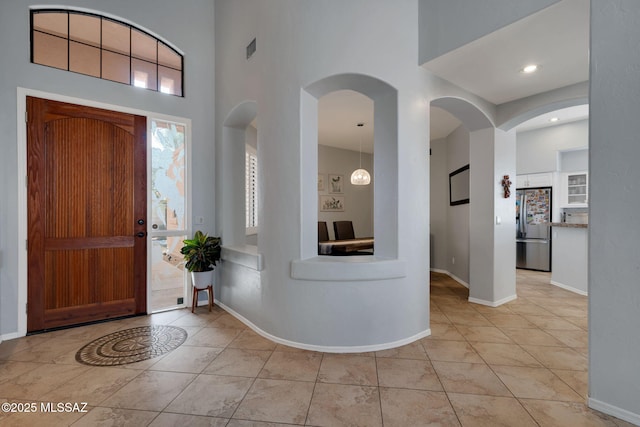 tiled foyer entrance featuring a high ceiling