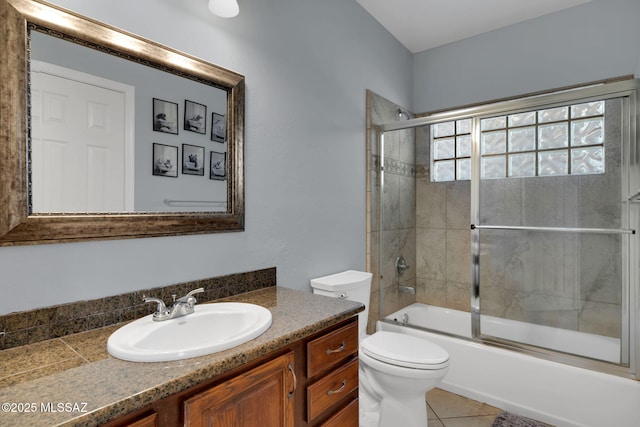 full bathroom with enclosed tub / shower combo, vanity, toilet, and tile patterned floors