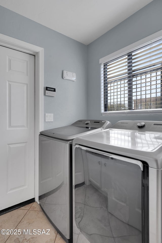 laundry room with light tile patterned floors and washing machine and clothes dryer