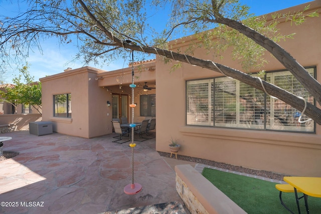 back of house with ceiling fan and a patio area