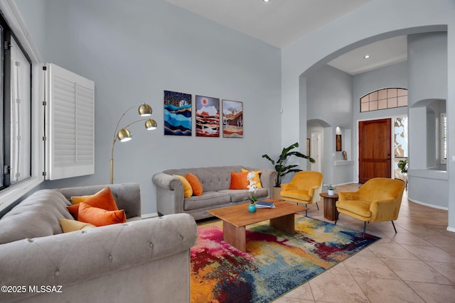 living room featuring light tile patterned floors and a high ceiling