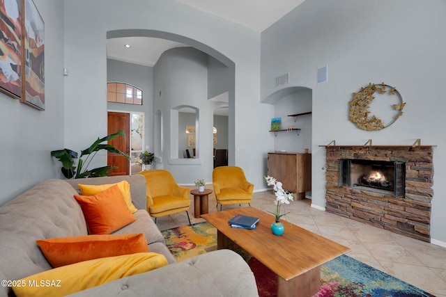 tiled living room featuring a high ceiling and a fireplace