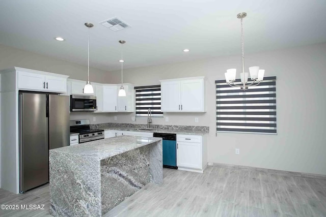 kitchen featuring visible vents, a center island, light wood-type flooring, appliances with stainless steel finishes, and white cabinets