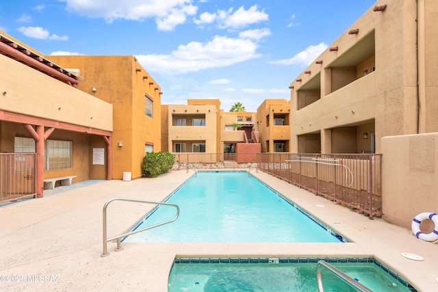 view of pool featuring a community hot tub and a patio area