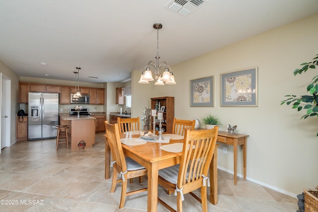 dining room with baseboards, visible vents, and a chandelier