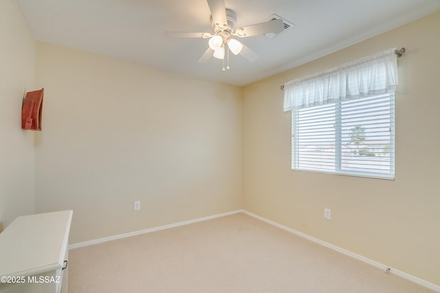 carpeted empty room featuring a ceiling fan and baseboards