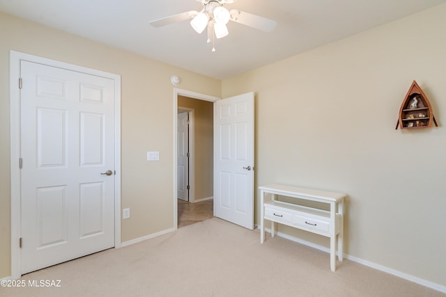 bedroom with light carpet, a ceiling fan, and baseboards