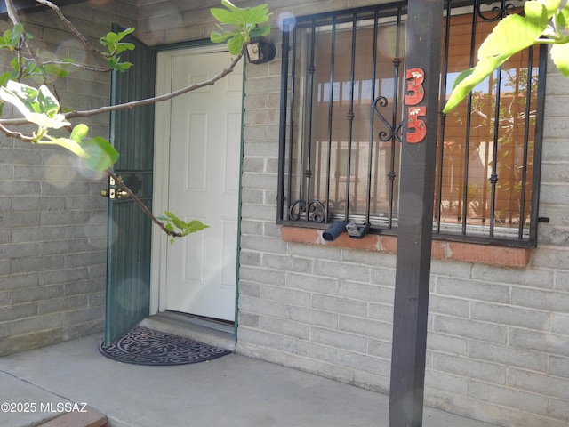 view of exterior entry featuring brick siding