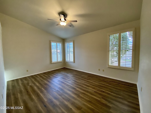 empty room featuring ceiling fan, lofted ceiling, dark hardwood / wood-style flooring, and a wealth of natural light