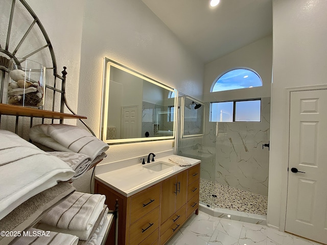 bathroom featuring vanity, lofted ceiling, and tiled shower