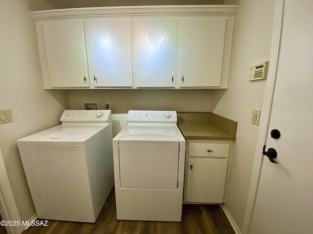 laundry room featuring cabinets, washer and dryer, and dark hardwood / wood-style flooring