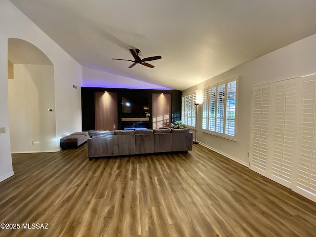 living room with ceiling fan, wood-type flooring, and vaulted ceiling