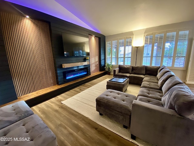 living room featuring lofted ceiling and light hardwood / wood-style flooring