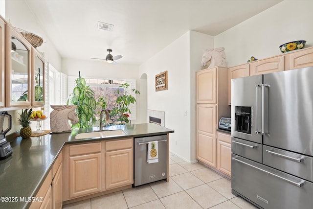 kitchen featuring visible vents, dark countertops, ceiling fan, appliances with stainless steel finishes, and a sink