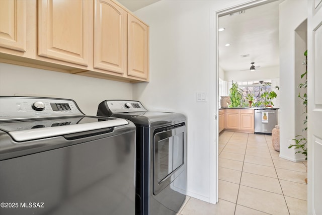 laundry area featuring light tile patterned floors, ceiling fan, washing machine and dryer, baseboards, and cabinet space
