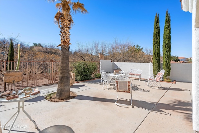 view of patio with outdoor dining space and fence