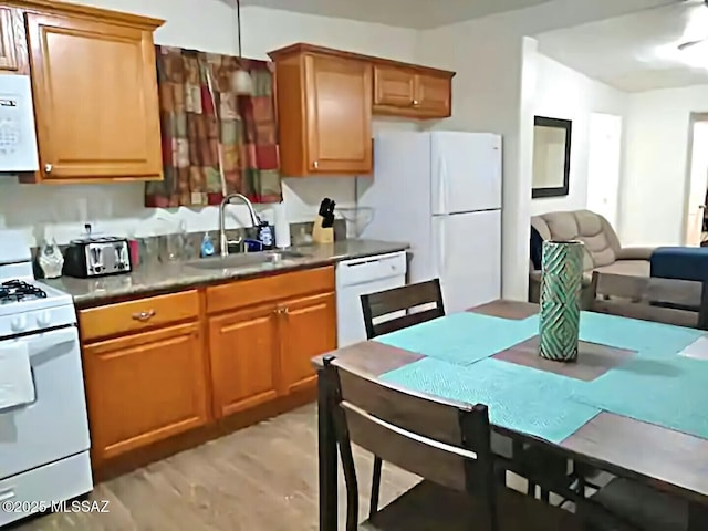 kitchen with sink, white appliances, and light hardwood / wood-style floors