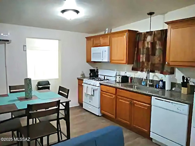 kitchen with sink, white appliances, and decorative light fixtures