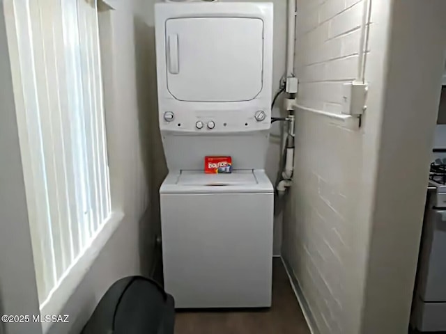 clothes washing area with stacked washer and dryer