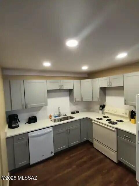 kitchen with gray cabinetry, sink, white appliances, and dark wood-type flooring