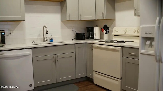 kitchen with gray cabinets, sink, and white appliances