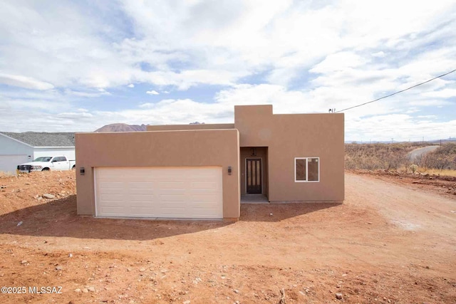 southwest-style home with stucco siding and an attached garage