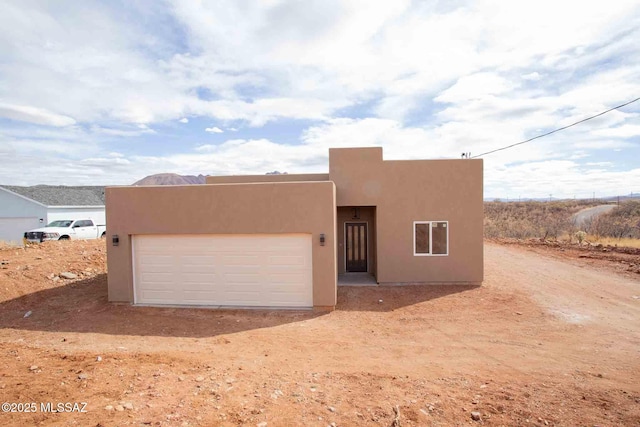 pueblo-style house with a garage