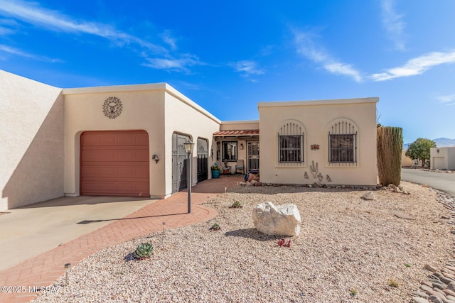 pueblo-style home featuring a garage