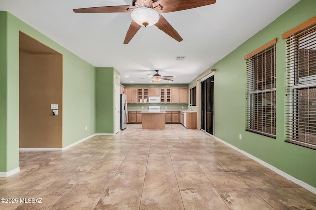 kitchen featuring sink, stainless steel fridge, ceiling fan, and light tile patterned flooring