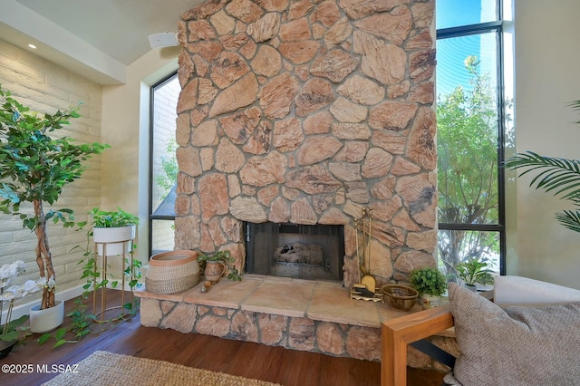 living room with hardwood / wood-style flooring and a stone fireplace