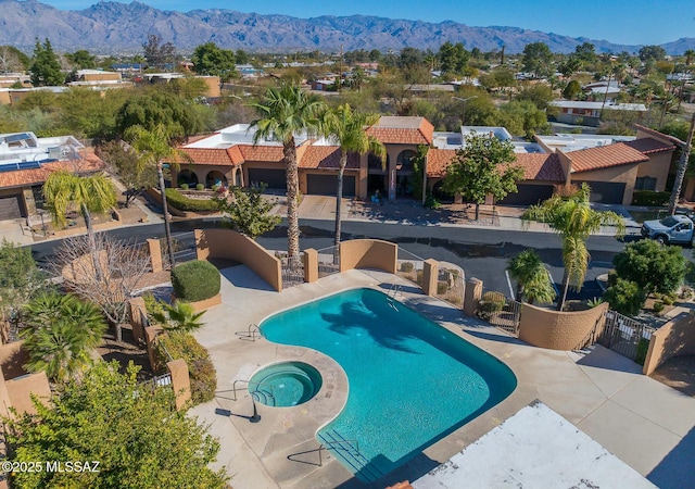 view of pool with a hot tub, a patio, and a mountain view