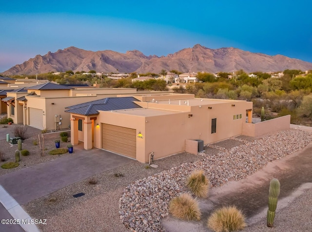 southwest-style home featuring a garage, a mountain view, and driveway