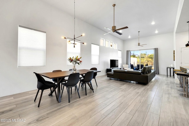 dining room featuring light wood-style floors, recessed lighting, a high ceiling, and an inviting chandelier