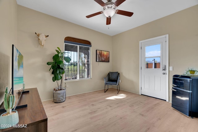 living area featuring a wealth of natural light, ceiling fan, and light hardwood / wood-style flooring