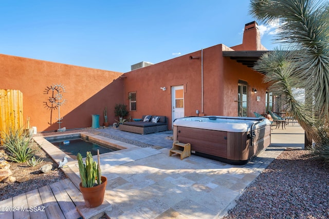 exterior space with a hot tub and a patio