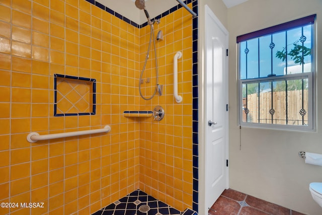 bathroom with tiled shower, tile patterned floors, and toilet