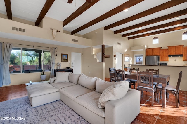 tiled living room featuring beamed ceiling, a towering ceiling, and ceiling fan